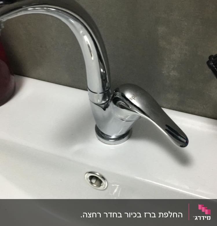 ברז כרום מותקן על כיור לבן עם ניקוז